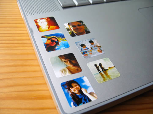 Vista parcial de teclado de laptop con pequeñas fotografías adheridas.